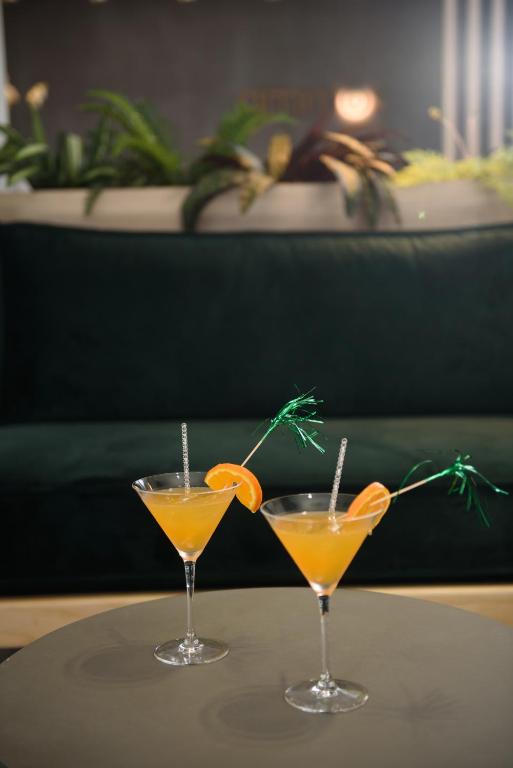 two glasses of orange juice sitting on a table at Ammos Beach Seaside Luxury Suites Hotel in Olympic Beach