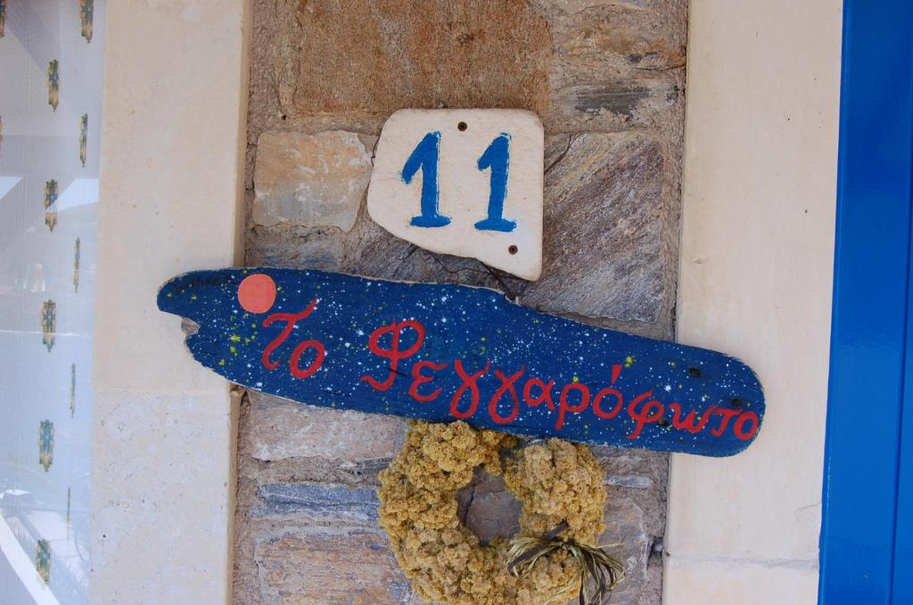 una pared de piedra con una placa con un número y una araña en Patras Apartments, en Fourni Ikarias