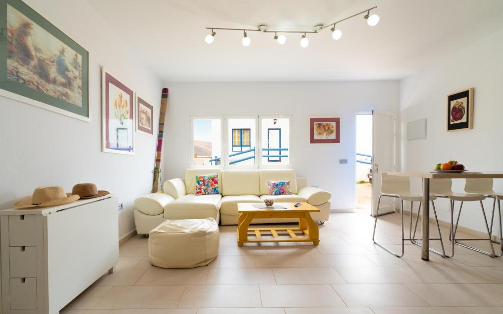 sala de estar con sofá blanco y mesa en APARTAMENTO LOS REMOS DE LA GRACIOSA, en Caleta de Sebo