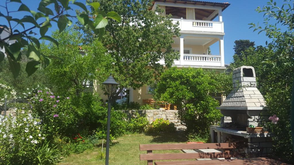 a park bench in front of a white building at Apartmani Slavica in Rab