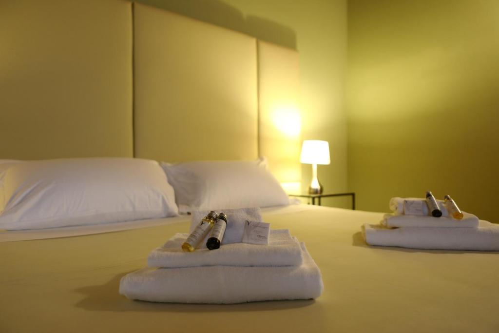 ペスキエーラ・デル・ガルダにあるOsteria Luxury Apartmentsのホテルルーム ベッド1台にタオル2枚付