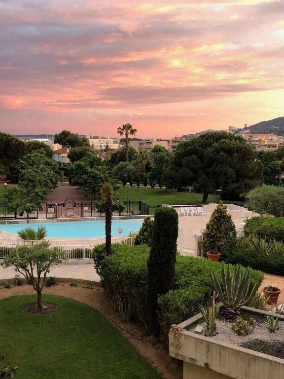 - une vue sur un parc avec une piscine dans l'établissement la villa des pins, à Juan-les-Pins