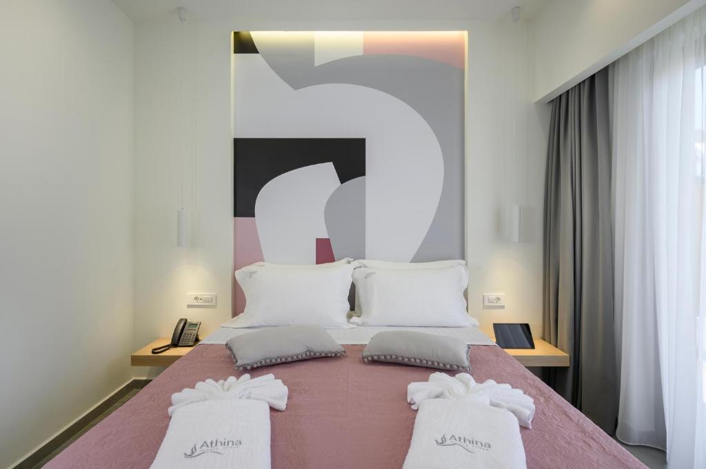a bedroom with a large bed with two white pillows at Athina Suites Luxury Suites Near The Sea Platanias in Platanias