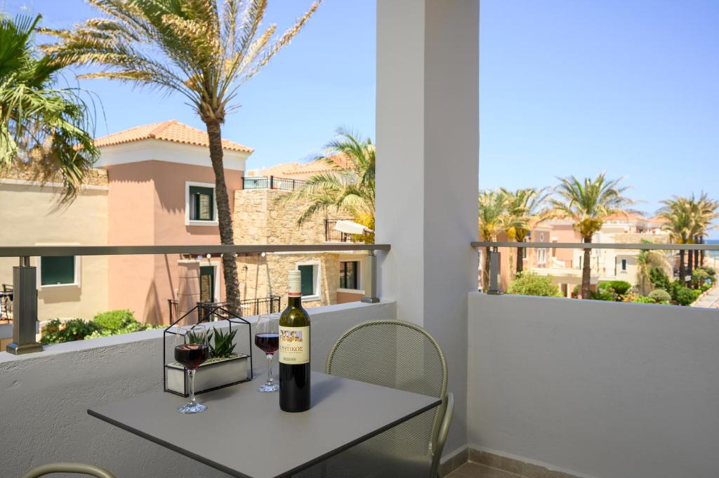 a bottle of wine on a table on a balcony at Athina Suites Luxury Suites Near The Sea Platanias in Platanias