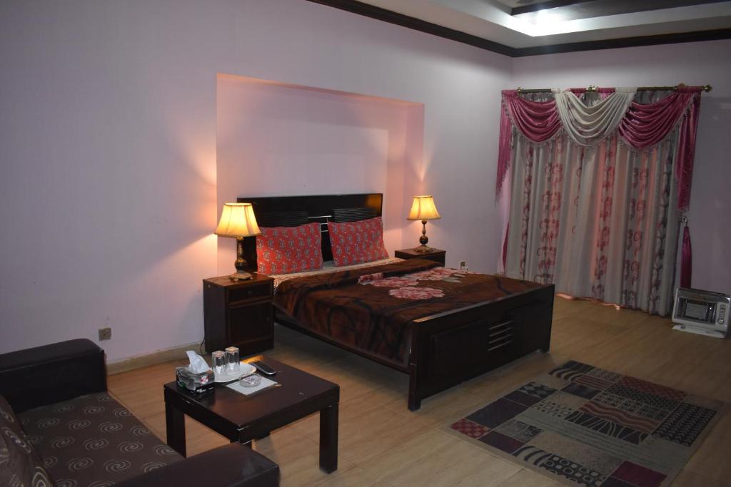 a living room with a bed and a couch at High Trees Inn in Islamabad