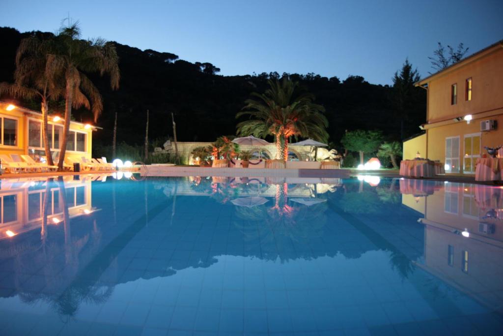ein großer Swimmingpool in der Nacht mit einem Hotel in der Unterkunft Park Hotel Paradiso in Piazza Armerina