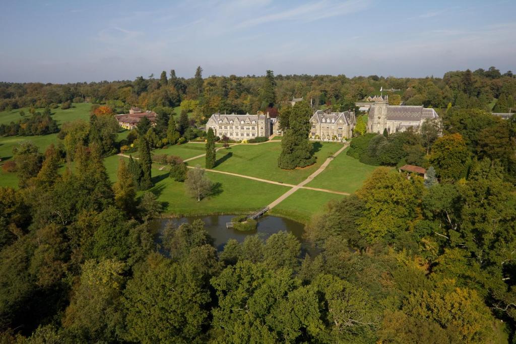 eine Luftansicht eines Herrenhauses mit See und Bäumen in der Unterkunft Ashdown Park Hotel in Forest Row