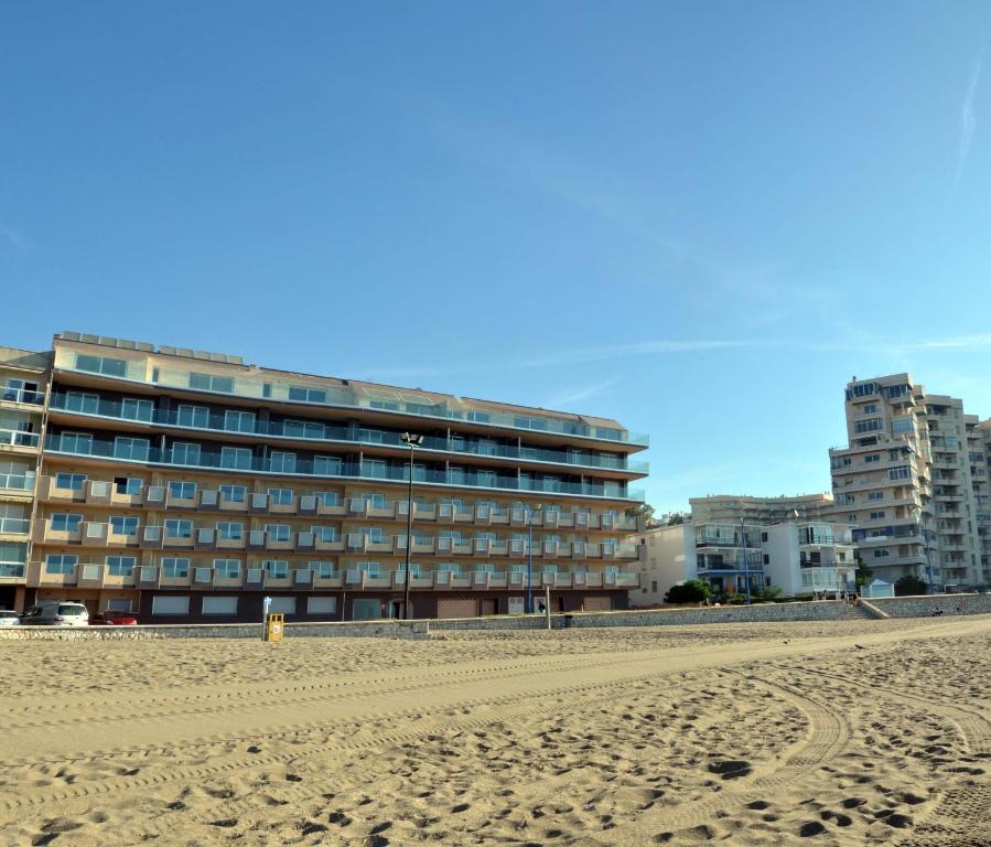 un edificio en la playa junto a una playa de arena en Vegasol Playa A.T, en Fuengirola