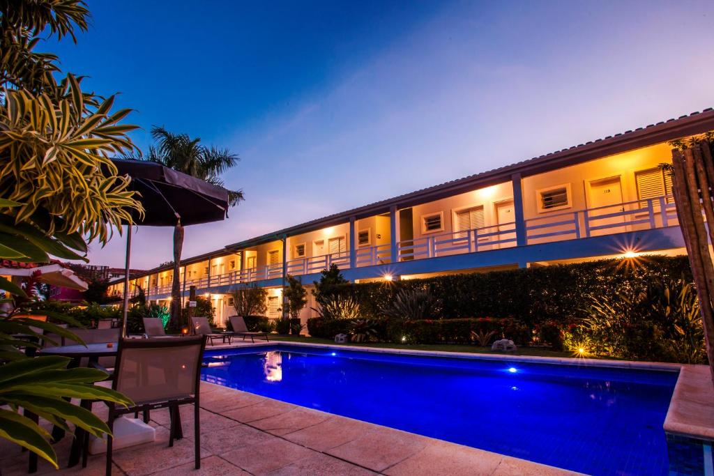 a hotel with a swimming pool at night at Pousada Azul da Cor do Mar in Maresias