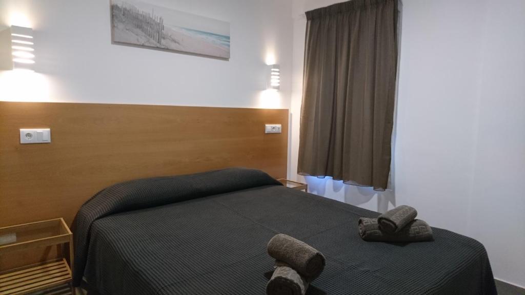 a bedroom with a bed with two towels on it at Bayside Salgados in Albufeira