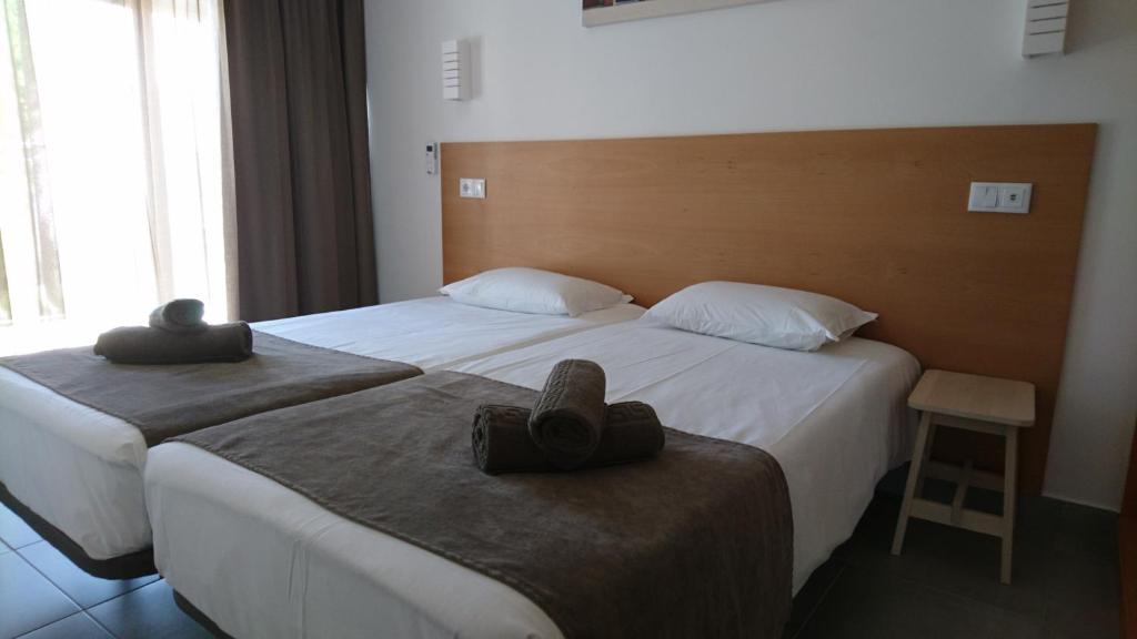 two beds in a hotel room with hats on them at Bayside Salgados in Albufeira