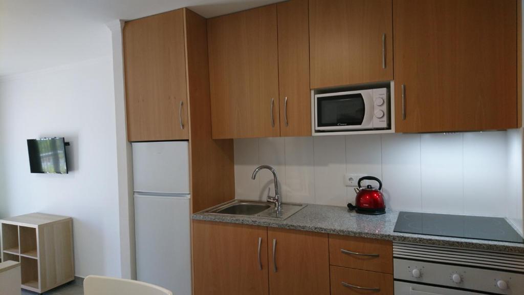 a small kitchen with a sink and a microwave at Bayside Salgados in Albufeira