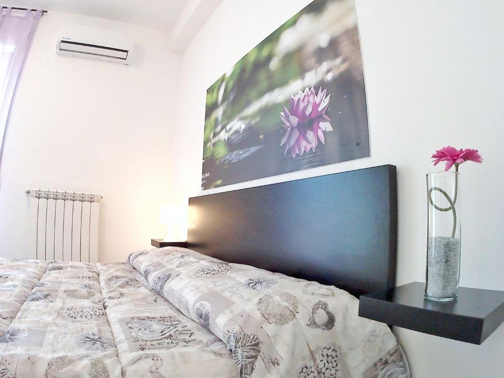 una camera con un letto e una foto appesa al muro di B&B Angelina a Triggiano