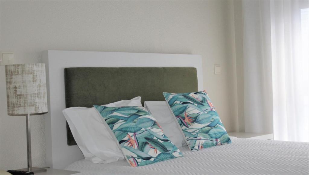 a bed with a white comforter and pillows at Classico in Vila Real