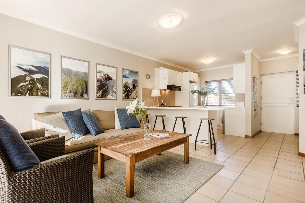 a living room with a couch and a table at 20 River Club Villas in Plettenberg Bay