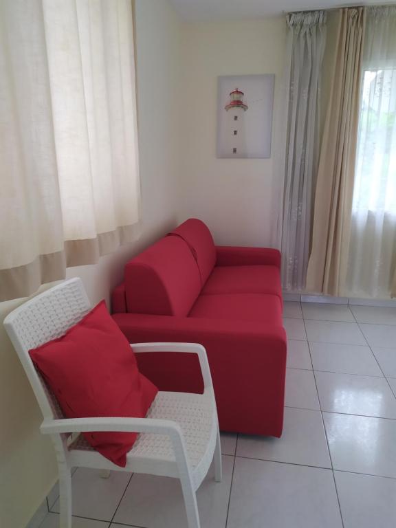 een woonkamer met een rode bank en een stoel bij Cocon proche Paris - CDG in Aulnay-sous-Bois