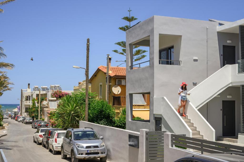 a woman is standing on the stairs of a house at Athina Suites Luxury Suites Near The Sea Platanias in Platanias
