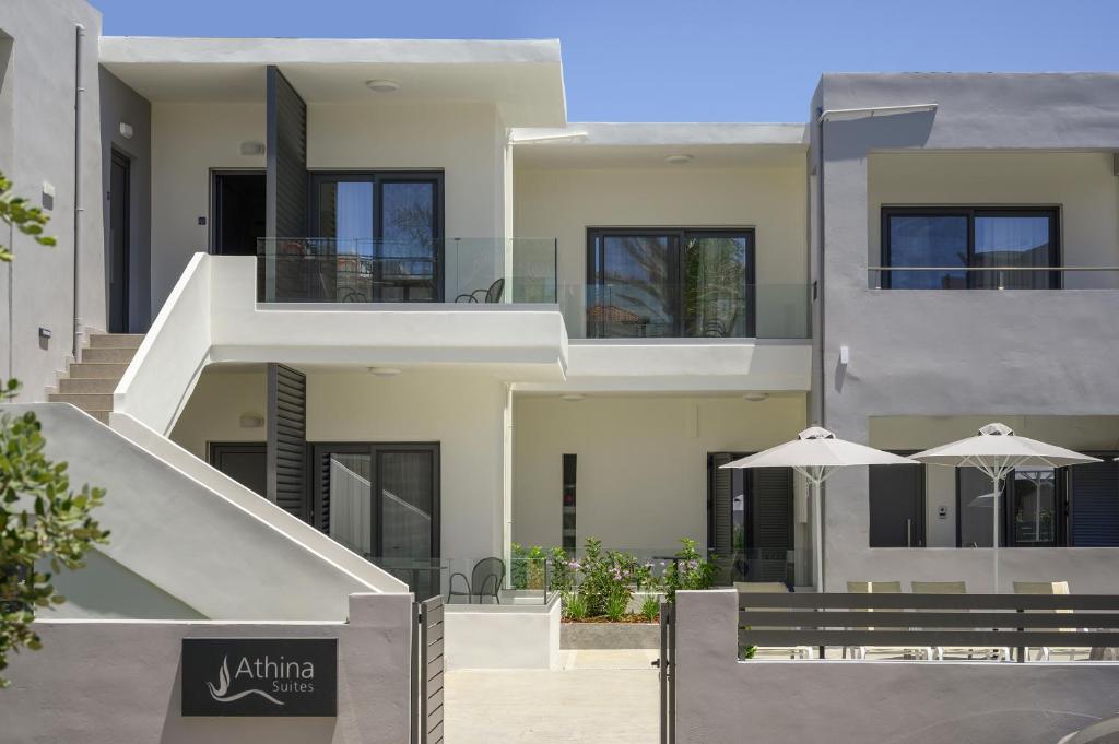 an external view of a building with stairs and umbrellas at Athina Suites Luxury Suites Near The Sea Platanias in Platanias