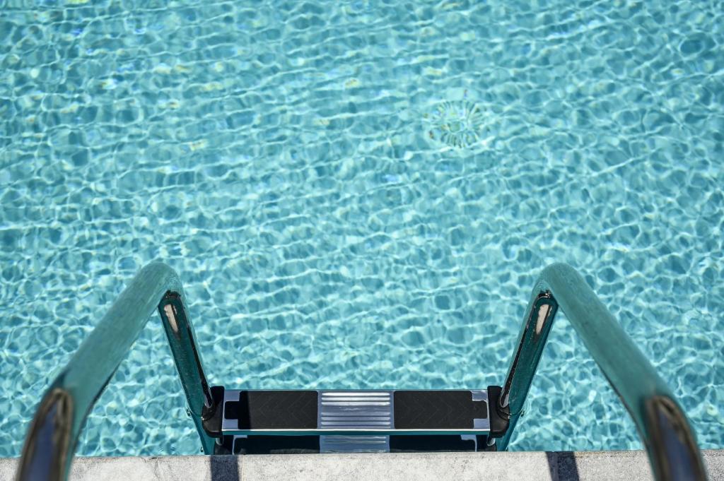 a chair in front of a swimming pool at Athina Suites Luxury Suites Near The Sea Platanias in Platanias