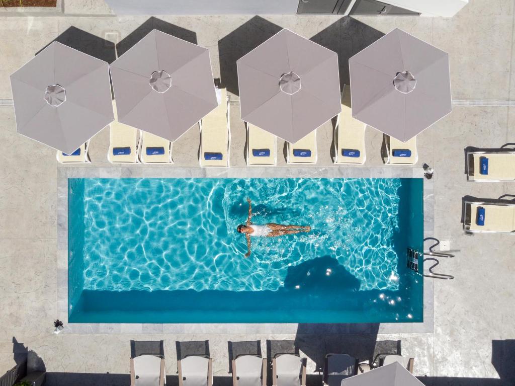an overhead view of a swimming pool with umbrellas at Athina Suites Platanias in Plataniás
