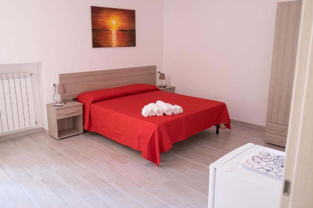 a bedroom with a red bed with a red blanket at B&B ELI in Rodi Garganico