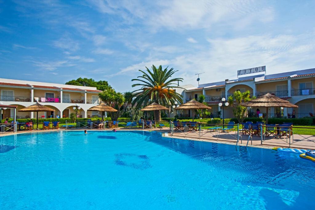 a large swimming pool in front of a hotel at Hotel Kalamitsi Apartments in Preveza