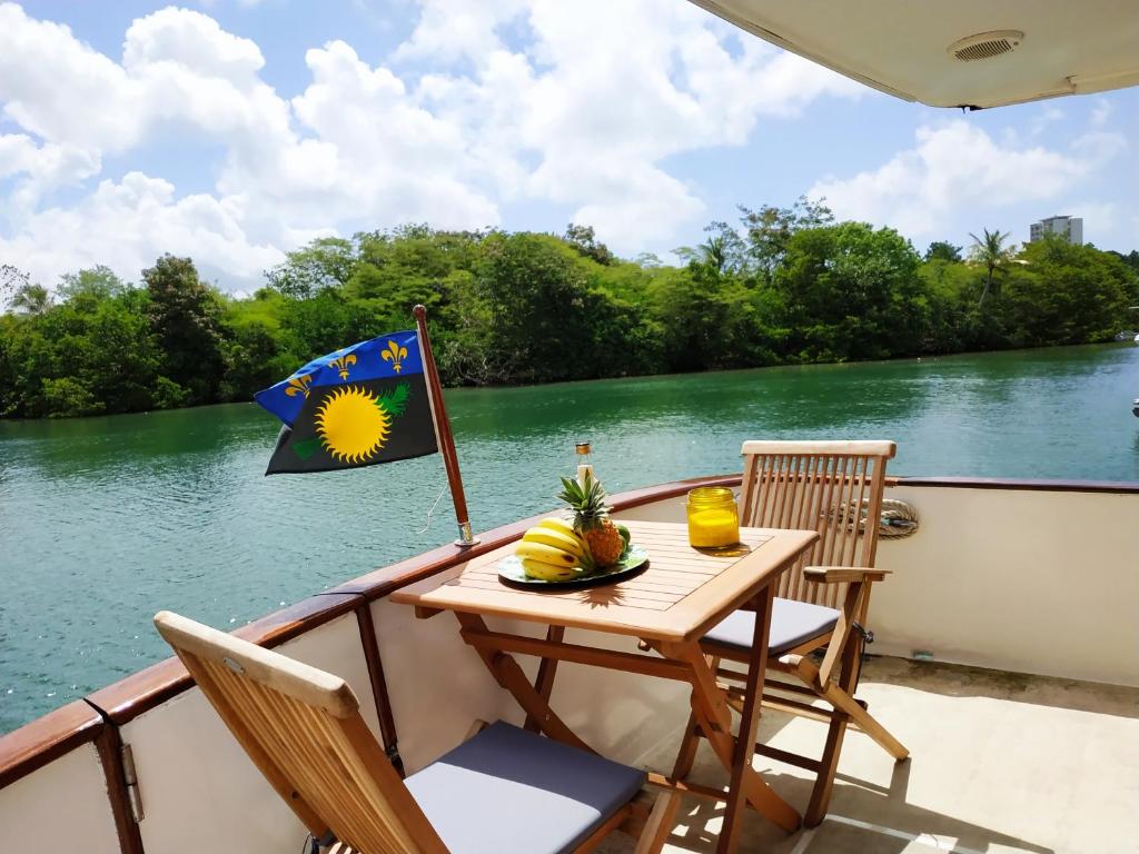 a table on the back of a boat with a flag at Queen Créole Séjour Romantique in Le Gosier