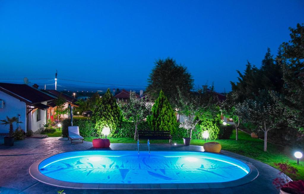a swimming pool in a backyard at night at Guest House Raiski Kаt in Mezek