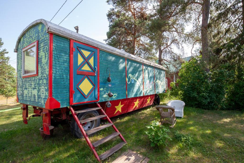 um pequeno vagão de comboio sentado na relva em Cirkus Hostel Holken em Inkoo