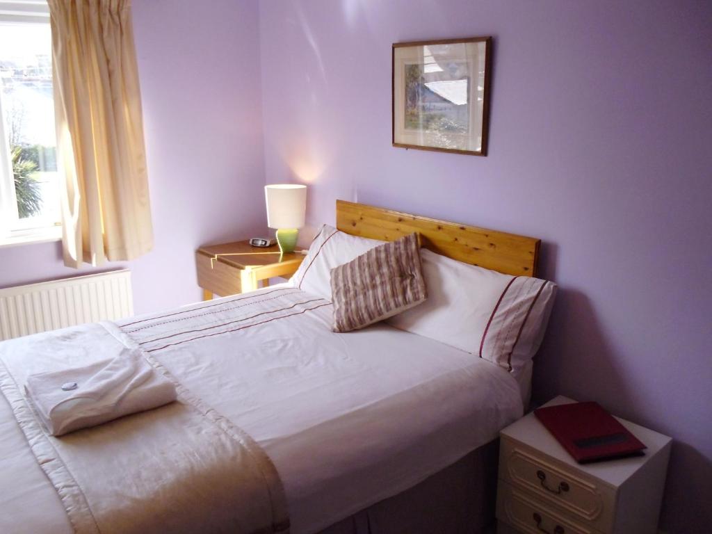 ein Schlafzimmer mit einem großen weißen Bett und einem Fenster in der Unterkunft Ellerton B&B in Bideford