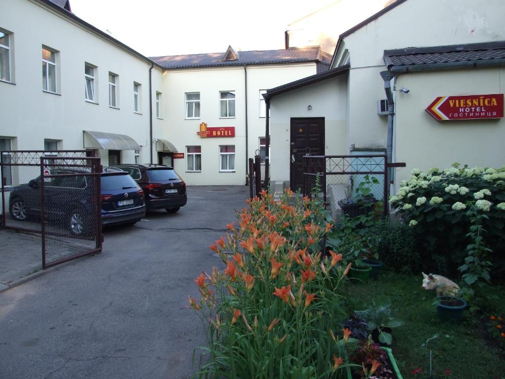 a parking lot with cars parked in front of a building at Leo in Daugavpils