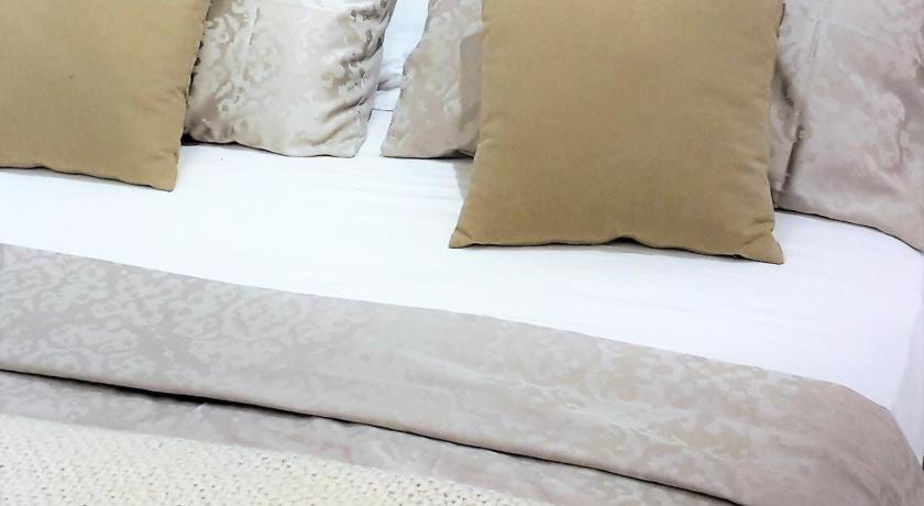 - un lit avec des draps et des oreillers blancs dans l'établissement San Lorenzo Cozy Studio, à Bergame