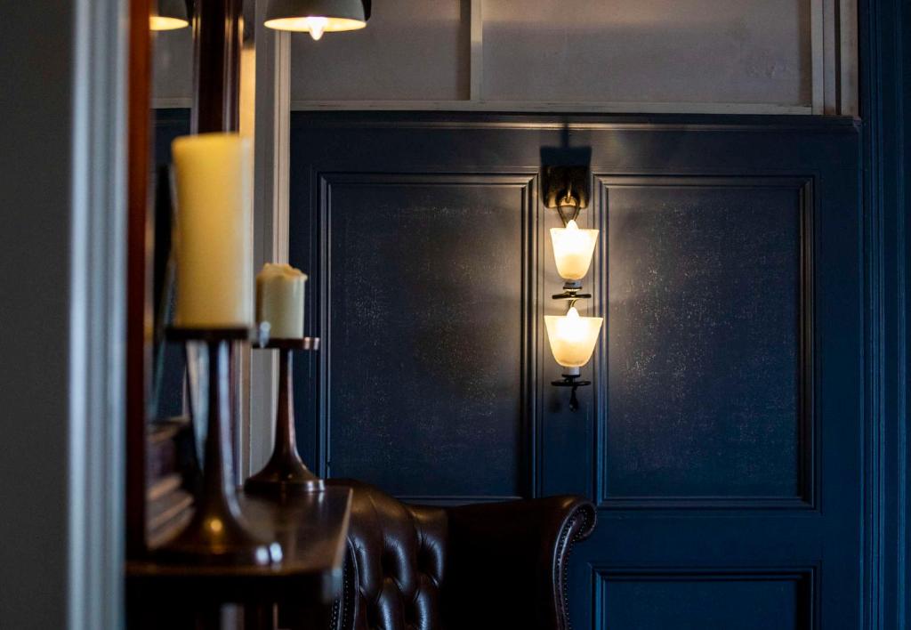 a room with a wall with two lights and a chair at Dunstan House in Burnham on Sea