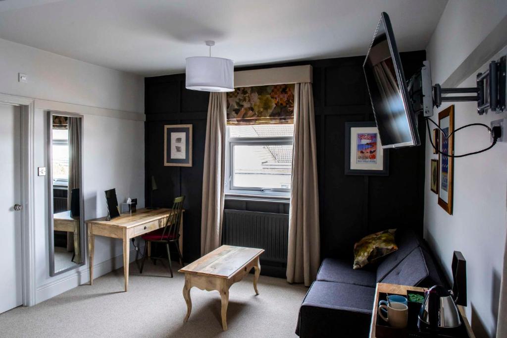 a living room with a blue couch and a table at Dunstan House in Burnham on Sea