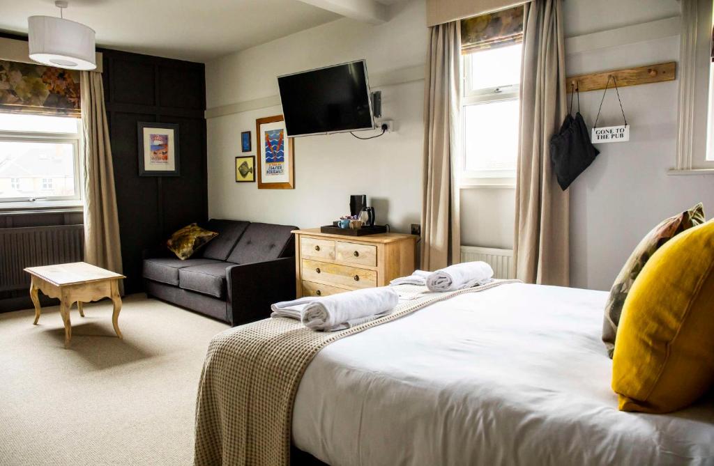 a hotel room with a bed and a couch at Dunstan House in Burnham on Sea