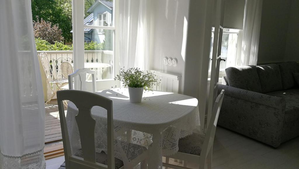 ハープサルにあるLinda Külaliskorterの窓付きの客室で、白いテーブルと椅子が備わります。