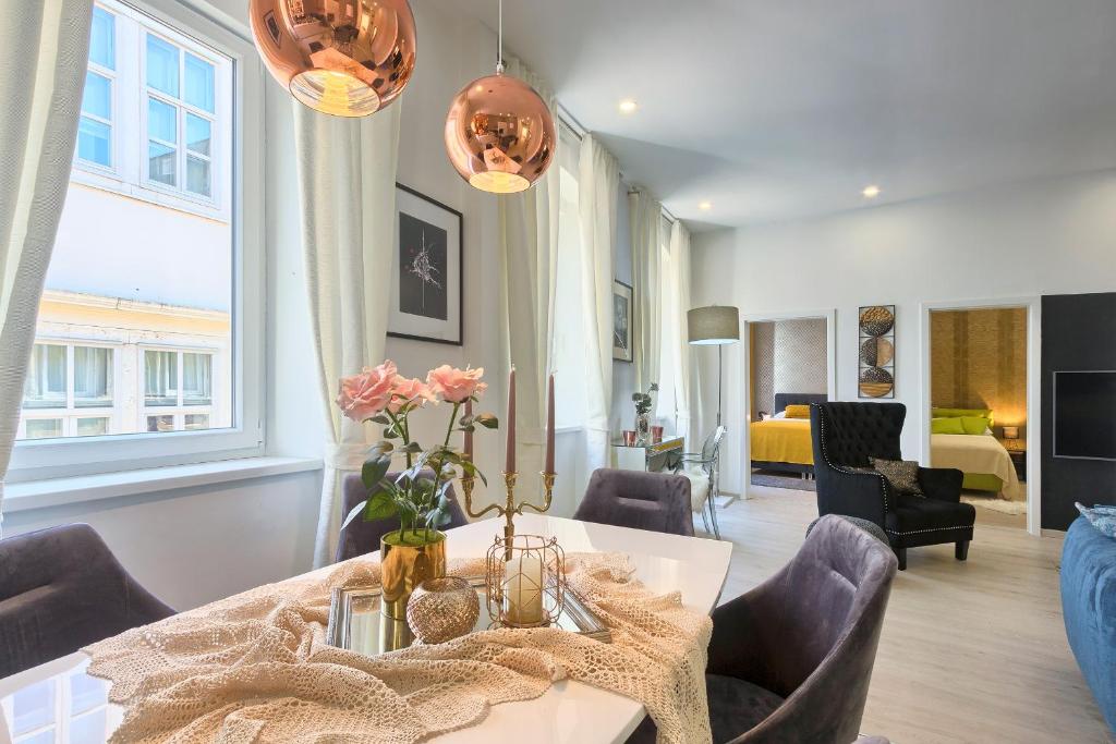 ein Wohnzimmer mit einem Tisch, Stühlen und einem Sofa in der Unterkunft Hedone Luxury Apartment with FREE PARKING in Pula