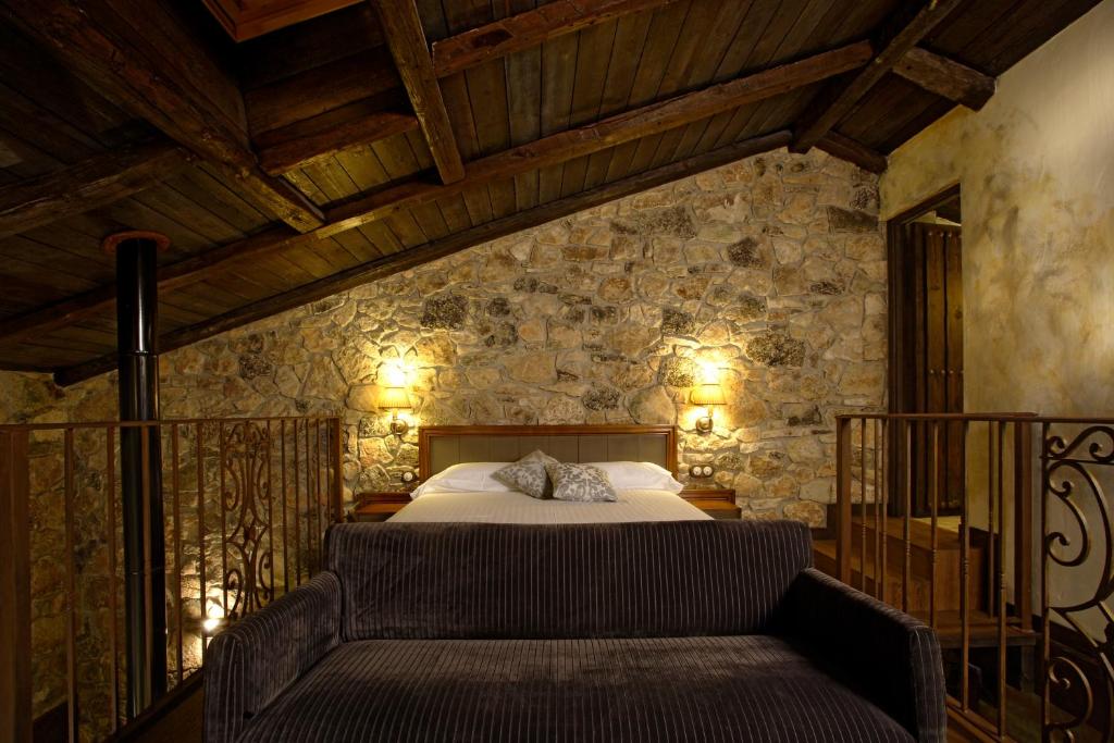 Un dormitorio con una cama y un sofá. en Hotel Rural & Spa Los Ánades, en Abánades