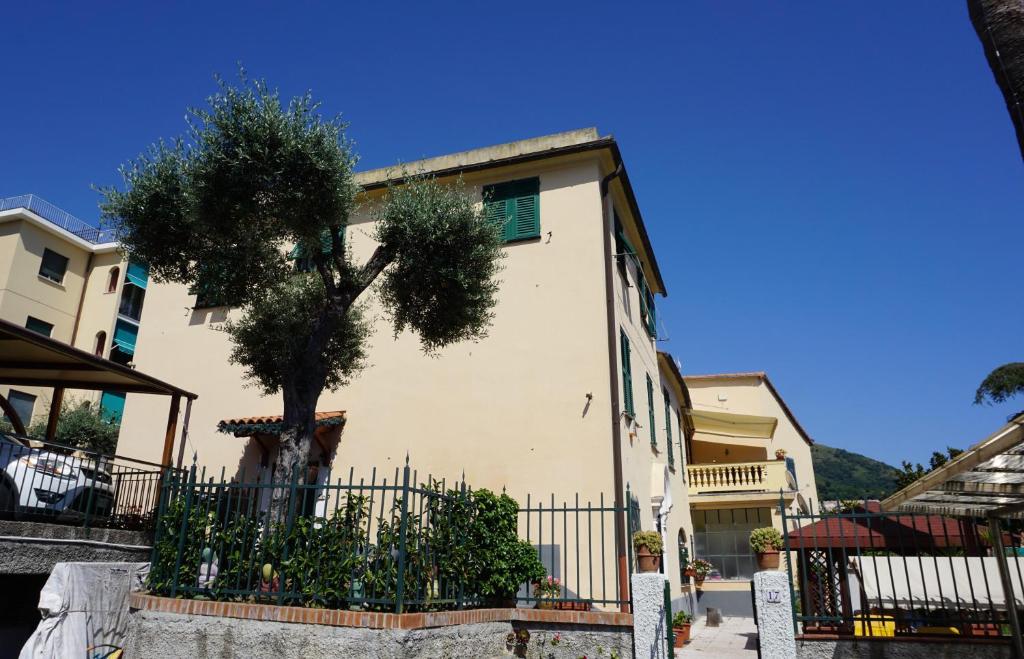 a building with a tree in front of a fence at Appartamento Villa Cristina in Genoa