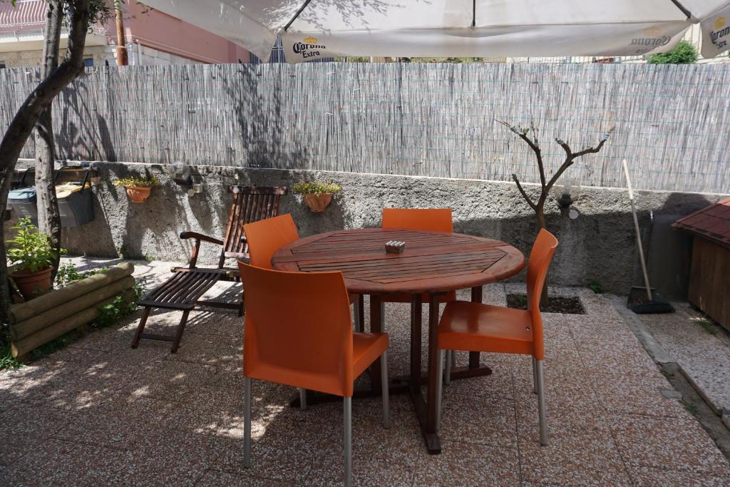 a wooden table with orange chairs on a patio at Appartamento Villa Cristina in Genoa