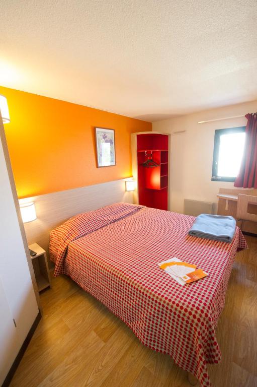 a hotel room with a bed with a red blanket at Premiere Classe Orleans Ouest - La Chapelle St Mesmin in La Chapelle-Saint-Mesmin
