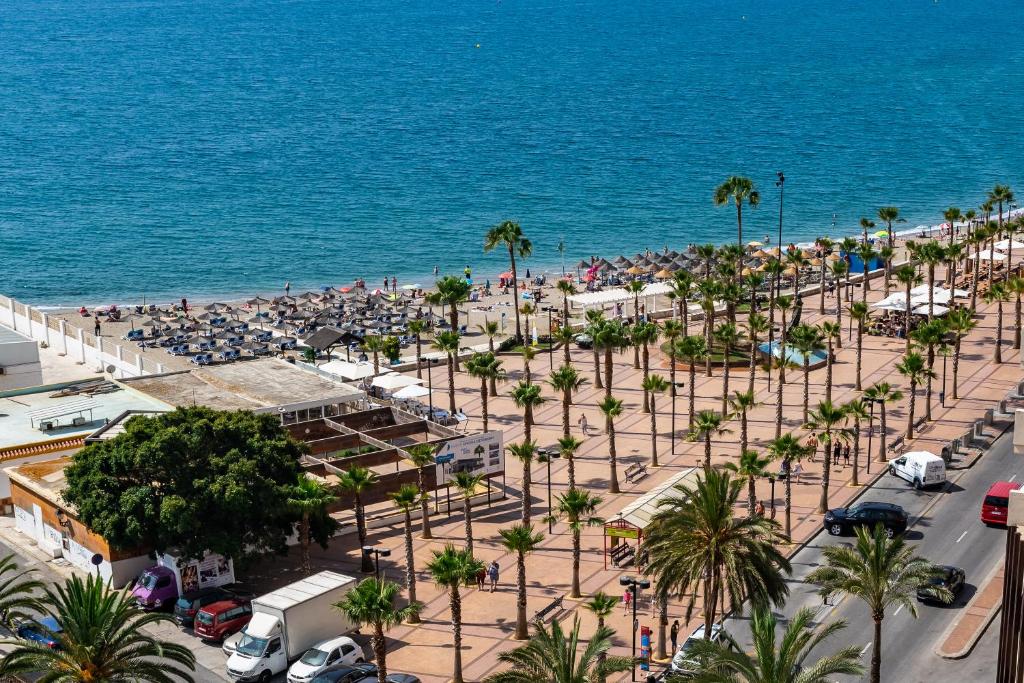 uma vista aérea de uma praia com palmeiras e do oceano em Sur Suites Perla 6 - 2 em Fuengirola