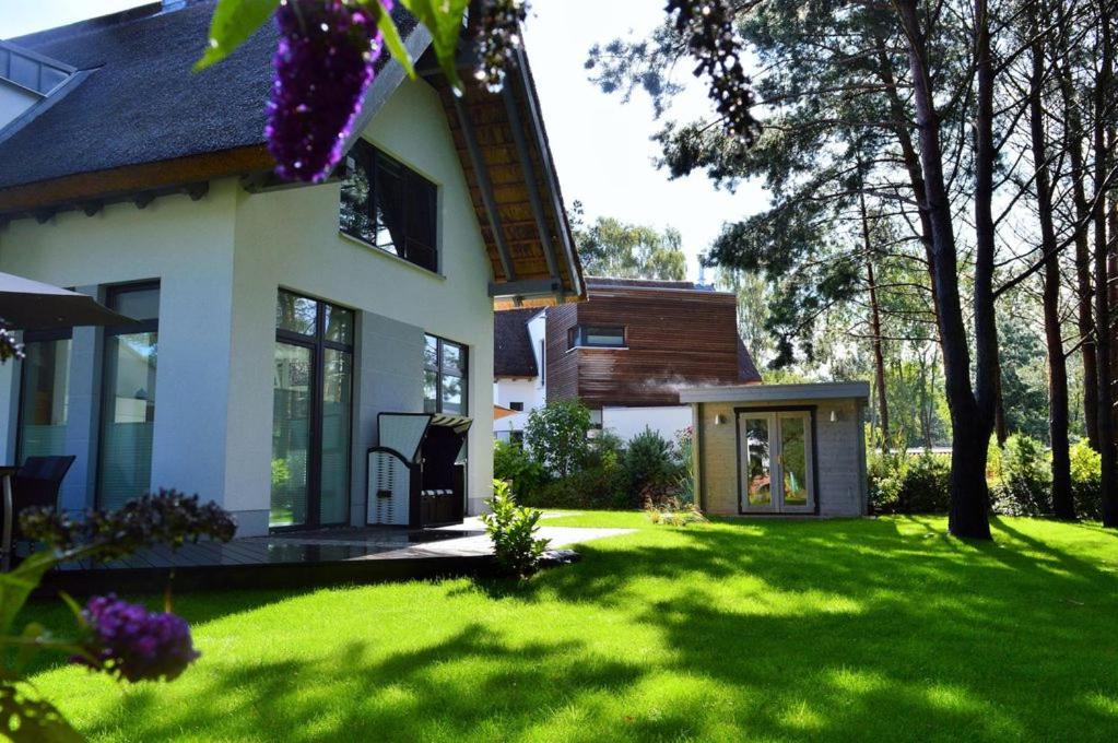 uma casa com um relvado verde em frente em Dat Segelhus em Ostseebad Karlshagen