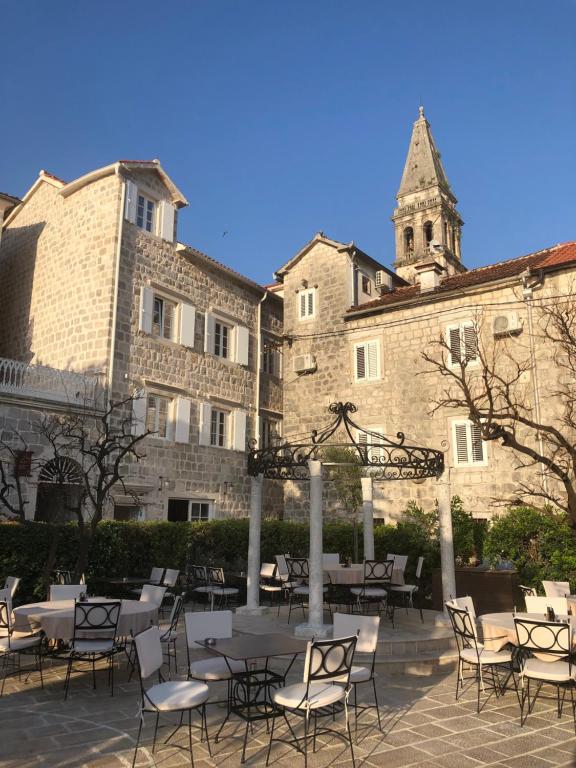 Heritage Hotel Leon Coronato في بيراتس: مجموعة طاولات وكراسي أمام المبنى