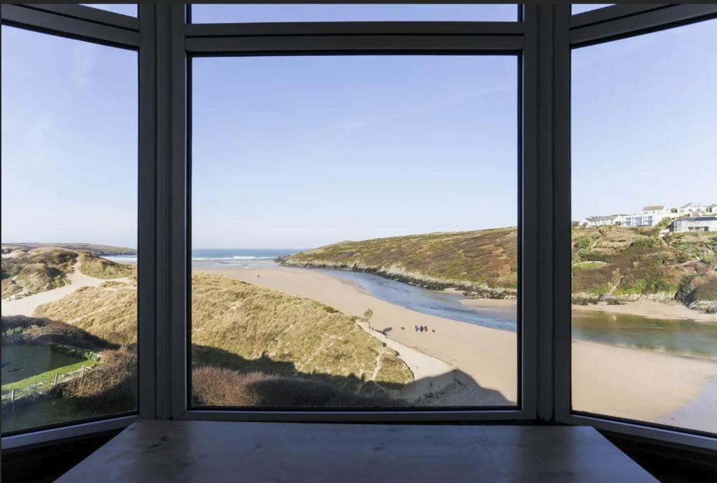 a view of a beach from a window at Chy-an-Lowena in Crantock