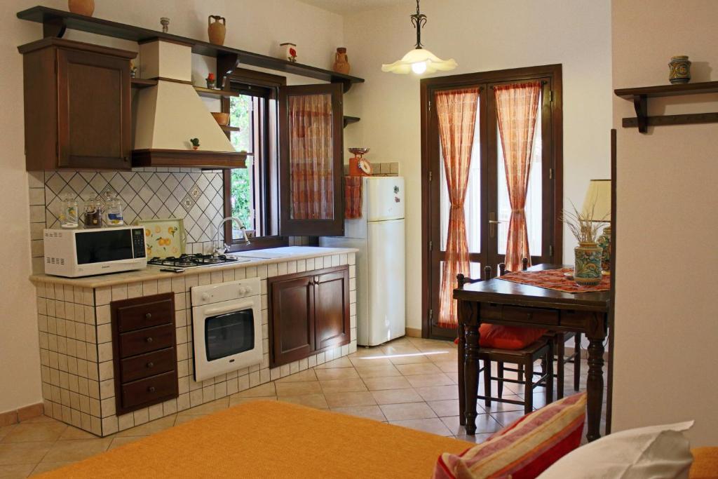 una cucina con frigorifero bianco e tavolo di Monolocale da Mariolina a Macari