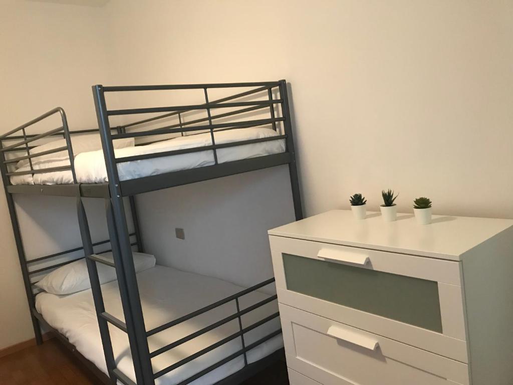 a bedroom with two bunk beds and a dresser at La cascata bianca in Riva del Garda