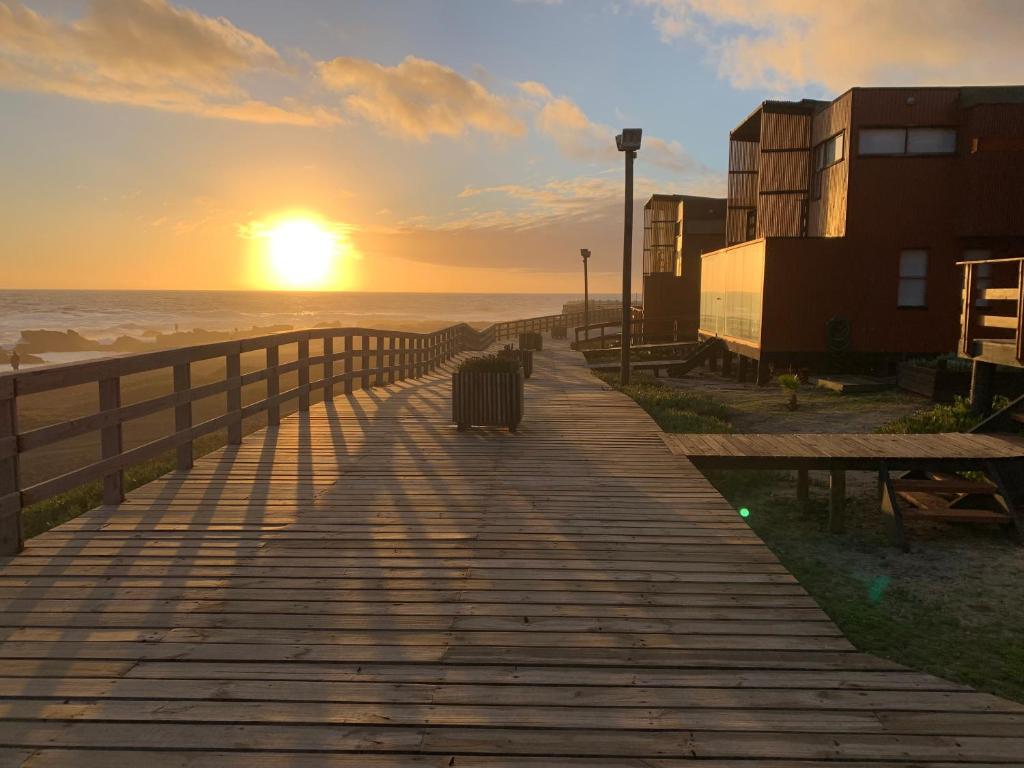 eine Promenade zum Strand bei Sonnenuntergang in der Unterkunft Casa con acceso directo a playa en condominio in Pichilemu