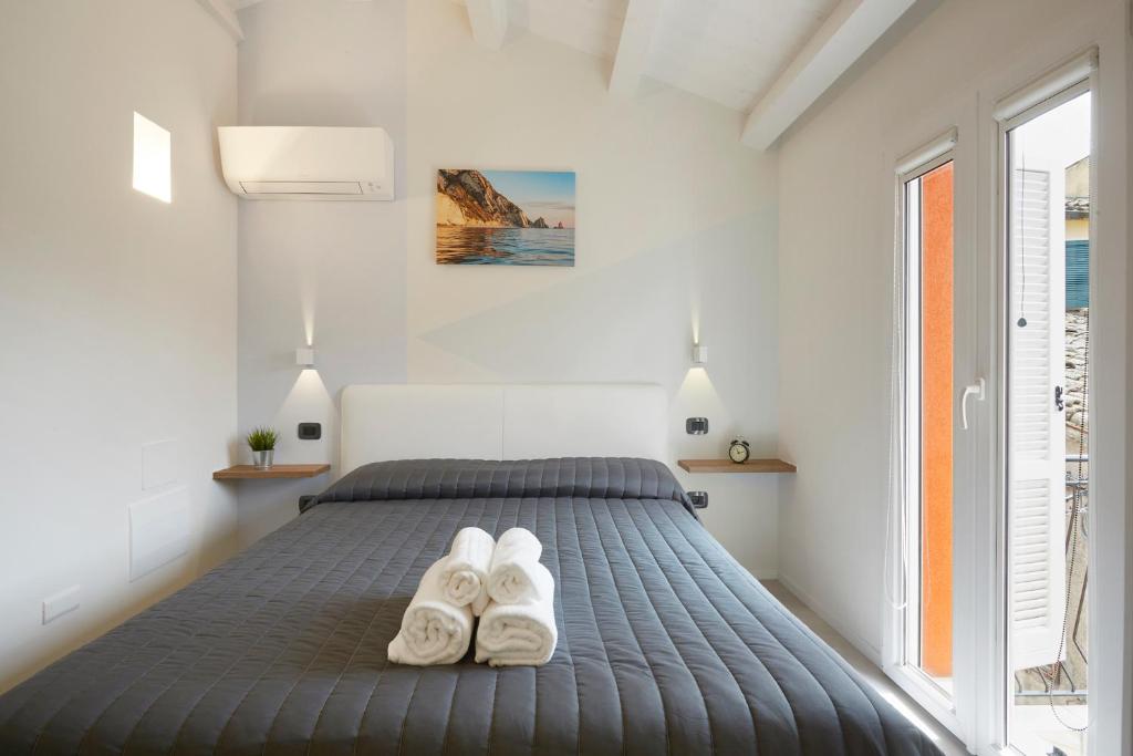 um quarto com uma cama e 2 chinelos brancos em Affittacamere Somnium em Sirolo