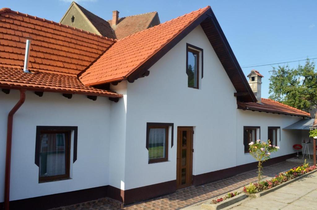 una casa blanca con techo naranja en Vik. Apartment en Sighişoara